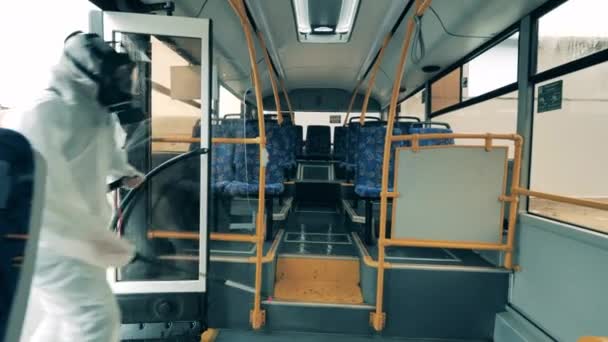 Desinfektorer använder sprutor för att desinficera en buss inifrån. — Stockvideo