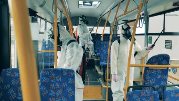 Folk desinficerar en stadsbuss med sprutor. — Stockvideo