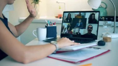 Bir çevrimiçi konferansa katılanlar birbirlerini selamlıyorlar. Bir grup iş arkadaşı video konferans uygulaması ve video çağrısı kullanarak konuşuyor. Evden çalışma, COVID-19 salgını.