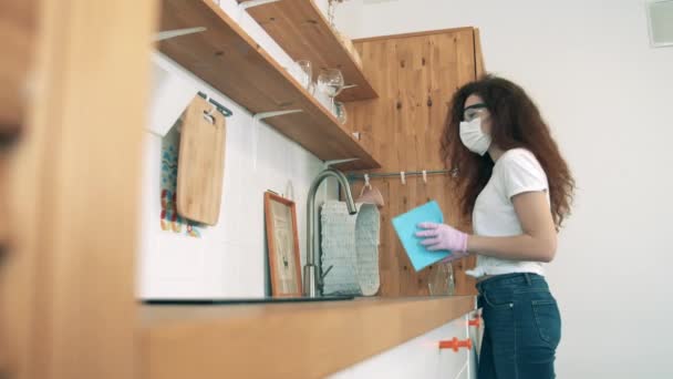 Μια γυναίκα καθαρίζει την κουζίνα με απολυμαντικό. — Αρχείο Βίντεο
