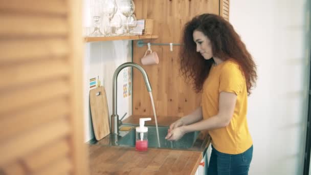 Linda senhora está lavando as mãos na cozinha — Vídeo de Stock