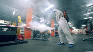 Ekipmanlı spor salonu bir hijyen işçisi tarafından dezenfekte ediliyor.