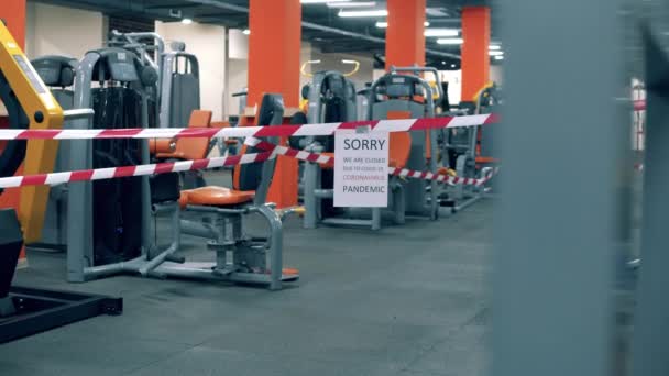 Centre de fitness vide avec un ruban d'avertissement et un avis de fermeture — Video