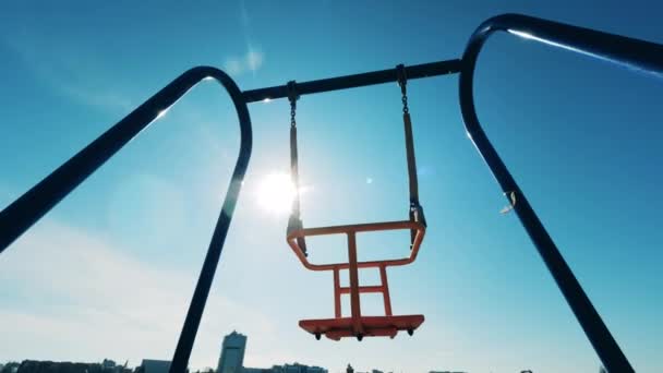 Balanços de luz do sol estão balançando sem ninguém neles — Vídeo de Stock