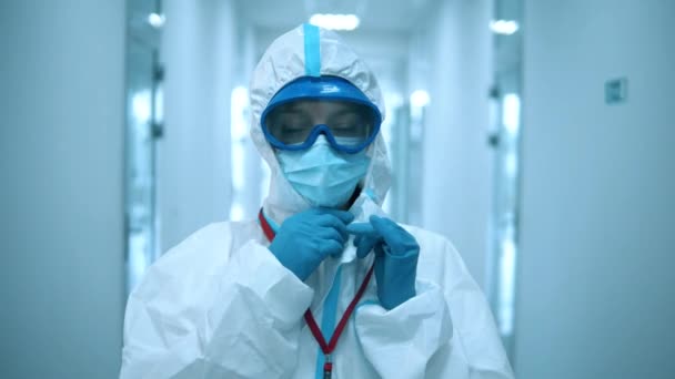 Γυναίκα γιατρός βγάζει μάσκα προσώπου μετά από μια εργάσιμη μέρα στην κλινική. — Αρχείο Βίντεο