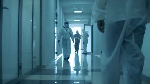 Ludzie noszą kombinezony ochronne podczas pracy w szpitalu podczas pandemii. — Wideo stockowe