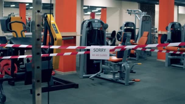 Gimnasio cerrado con cinta de advertencia envuelta alrededor de las máquinas — Vídeos de Stock
