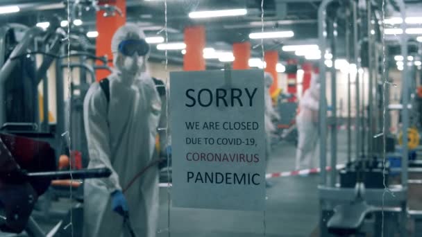 衛生労働者は閉鎖フィットネスセンターを消毒しています — ストック動画