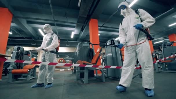 Inspectors are spraying chemicals in the equipped gym — Stock Video