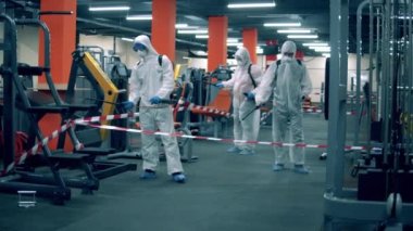 Bir grup uzman fitness merkezini dezenfekte ediyor.