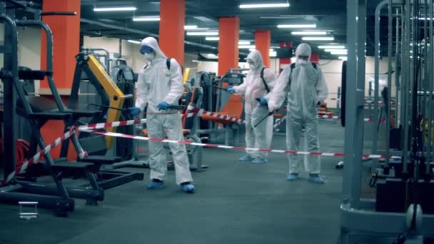 A szakértői csoport fertőtleníti a fitneszközpontot. — Stock videók