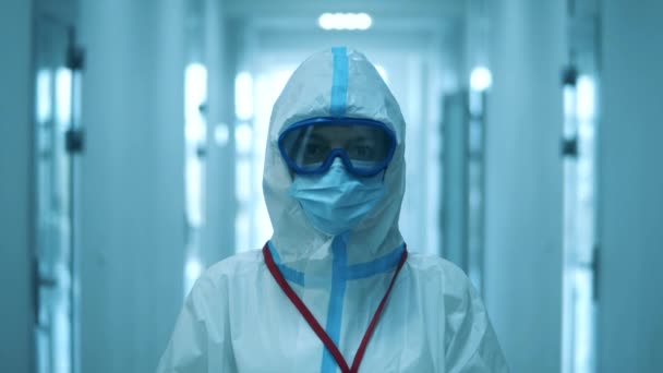 A woman looks at camera, while wearing protective suit. — Stock Video