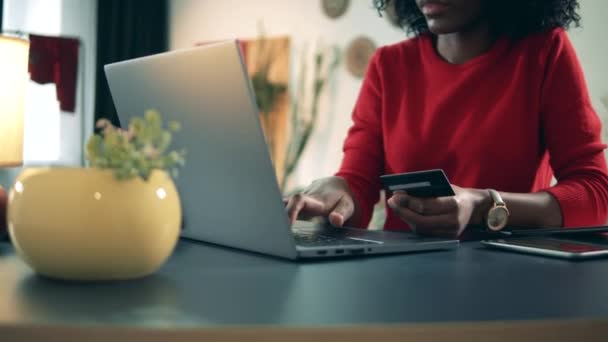Інтернет-магазин коктейлів. Африкансько-американська жінка використовує ноутбук і картку для магазину в закритому режимі. Відсутня покупка, концепція онлайн купівлі. — стокове відео
