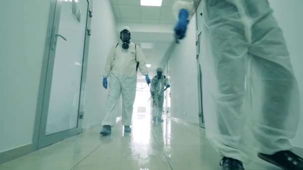 Group of specialists are sanitizing a white hallway — Stock Video