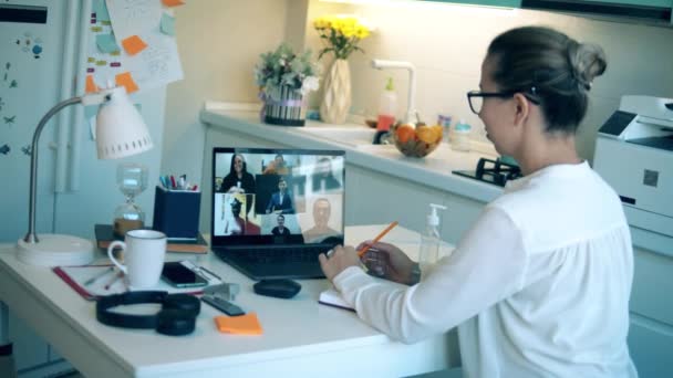 Trabajadora se comunica con las personas a través de computadora portátil durante la cuarentena . — Vídeo de stock
