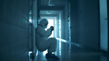 Doktor yorgun düşerken duvardan kayıyor.