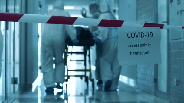 Концепція Covid-19. Небезпечний зал з лікарями, що перевозять пацієнта через нього — стокове відео