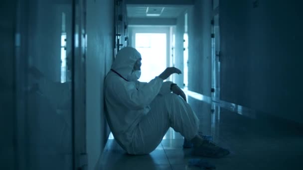 Trött sjukvårdare har en paus på golvet i hallen — Stockvideo