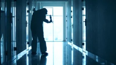 Doktor koridorda yürüyor ve dinlenmek için oturuyor.