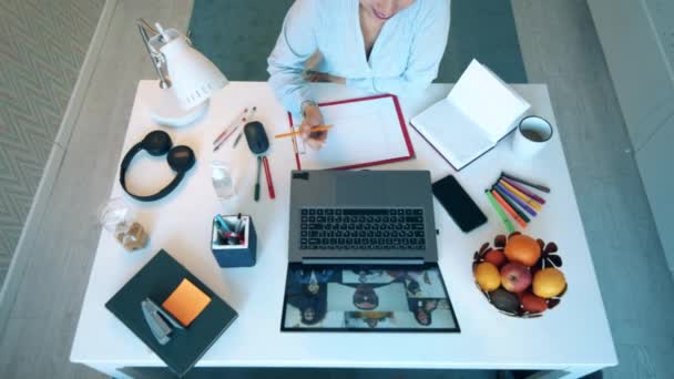 Visão superior da mesa das mulheres durante a sua chamada de conferência. Encontro on-line, trabalho remoto usando videocall . — Vídeo de Stock