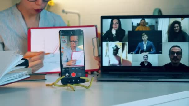 Videollamada realizada por una mujer y sus colegas. Reunión en línea, trabajo remoto usando videocall . — Vídeo de stock