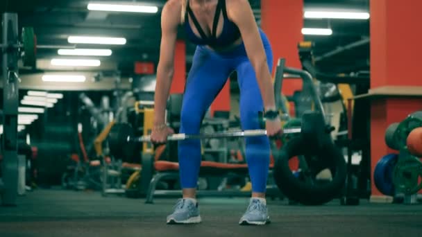 Centre de remise en forme avec une femme soulevant un bar dedans — Video