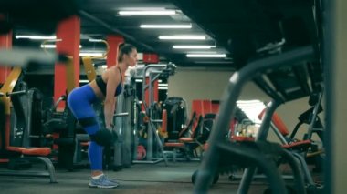 Atletik bayan spor salonunda kaldırma egzersizi yapıyor.