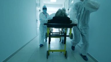 Hastanenin koridorunda bir grup doktor bir hastanın yerini değiştiriyor. Coronavirus Hastanesi, COVID-19 Klinik Konsepti.