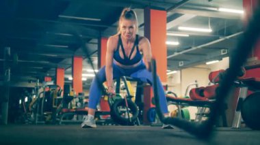 Bir bayan spor salonunda çapraz egzersiz yapıyor.