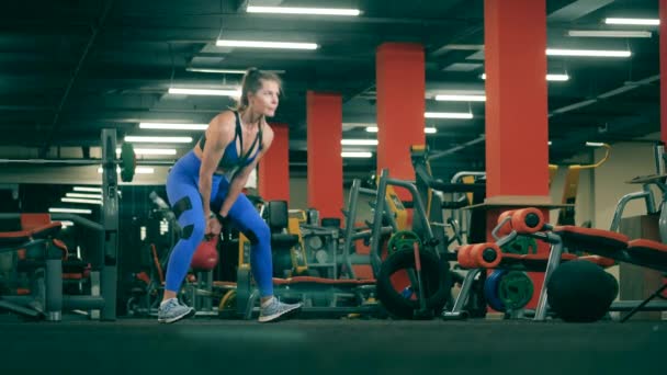 Eine Frau macht Gewichtheben im Fitnessstudio — Stockvideo