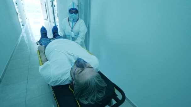Ασθενής COVID-19 στο νοσοκομείο Coronavirus. Ένας ασθενής με αναπνευστήρα πάνω του μεταφέρεται. — Αρχείο Βίντεο