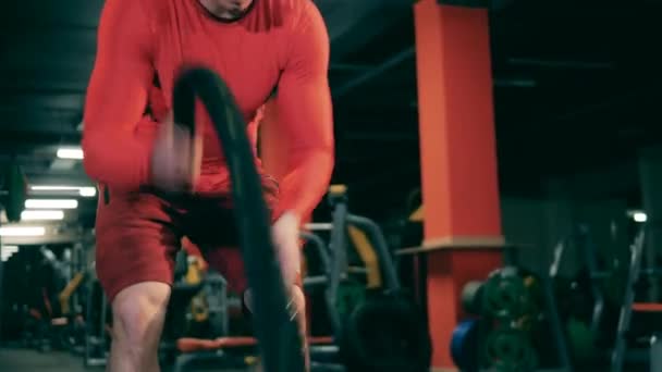 Crossfit pratique est faite par un jeune homme dans la salle de gym — Video
