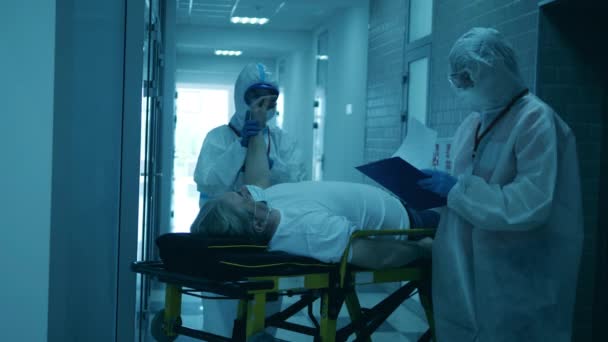 Especialistas médicos estão examinando um paciente deitado — Vídeo de Stock