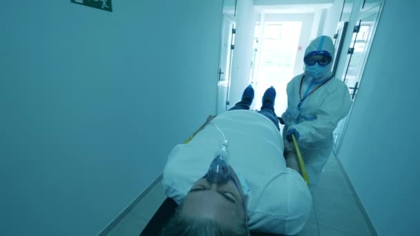 Záchranář v ochranném obleku přemisťuje lživého pacienta. — Stock video