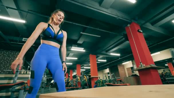 Uma mulher está fazendo uma pausa e depois começa a fazer crossfit — Vídeo de Stock