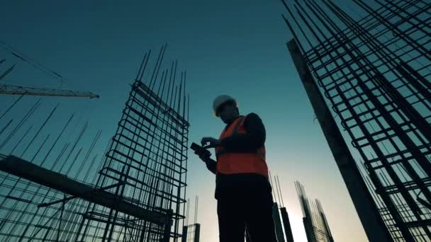 Een ingenieur controleert bouwplaats met wapening. — Stockvideo