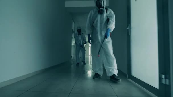 Οι απολυμαντές καθαρίζουν ένα διάδρομο για να σκοτώσουν τον κορωναϊό.. — Αρχείο Βίντεο