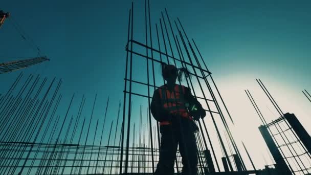 Byggherre, byggnadsarbetare med metallkonstruktion på en byggarbetsplats. — Stockvideo