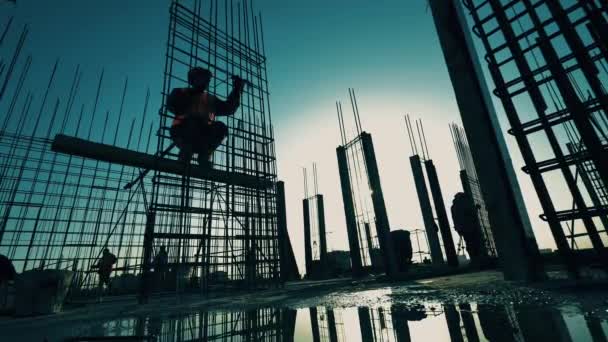 Mensen werken op de bouwplaats, repareren karkas. — Stockvideo