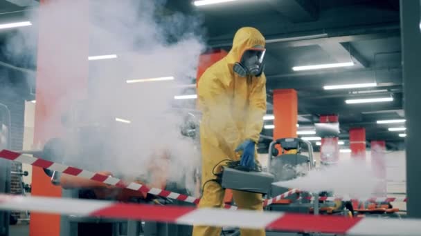 Man in hazmat desinfecteert sportschool met een sproeiapparaat. — Stockvideo