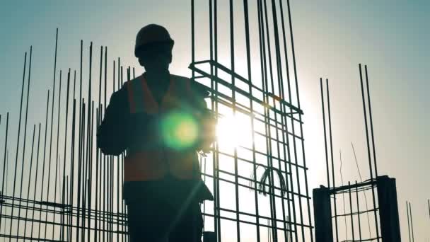 Um homem trabalha com barras de reforço no canteiro de obras . — Vídeo de Stock