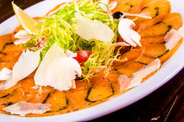 Meze. Somon carpaccio beyaz plaka üzerinde parmesan peyniri ile