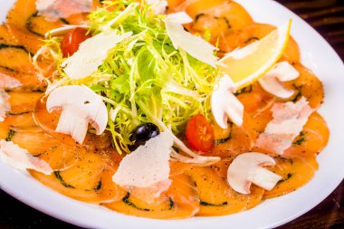 Meze. Somon carpaccio beyaz plaka üzerinde parmesan peyniri ile