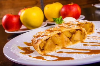 Strudel elma ve beyaz plaka üzerinde dondurma ile