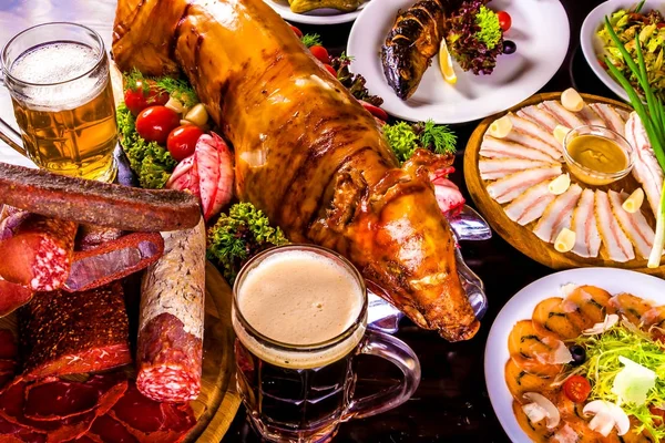 Gıda tablo. Kavrulmuş domuz yavrusu, ızgara balık, soğuk haşlanmış domuz, bira ve mezeler