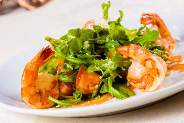 Beyaz tabakta roka, karides, somon ve parmesan peynirli salata