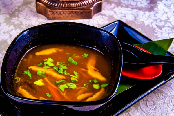 Asian spicy soup with vegetables in black plate — Stock Image Asian Spicy Soup Vegetables Black Plate Stock Photo