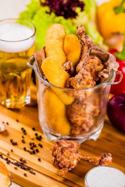 Balık kroket ve cam kase içinde kızarmış tavuk bira ile hizmet