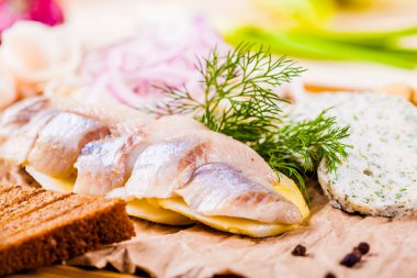 Meze. Ringa balığı, haşlanmış patates, ekmek, turşu, soğan ahşap tahta üzerinde