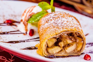 Strudel apple ve beyaz plaka üzerinde dondurma ile